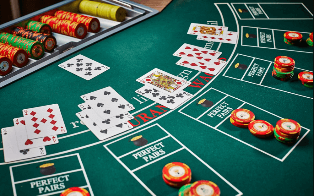 Blackjack table with cards dealt and chips placed by players and the dealerp