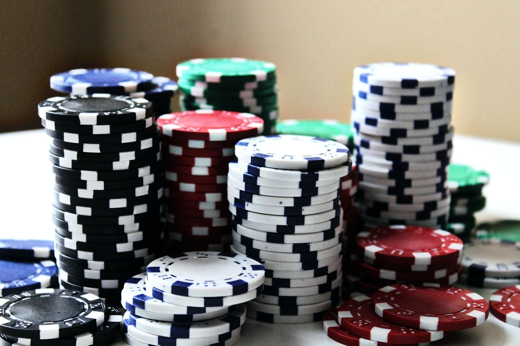 Poker chips of various colors and stacks arranged on a table.