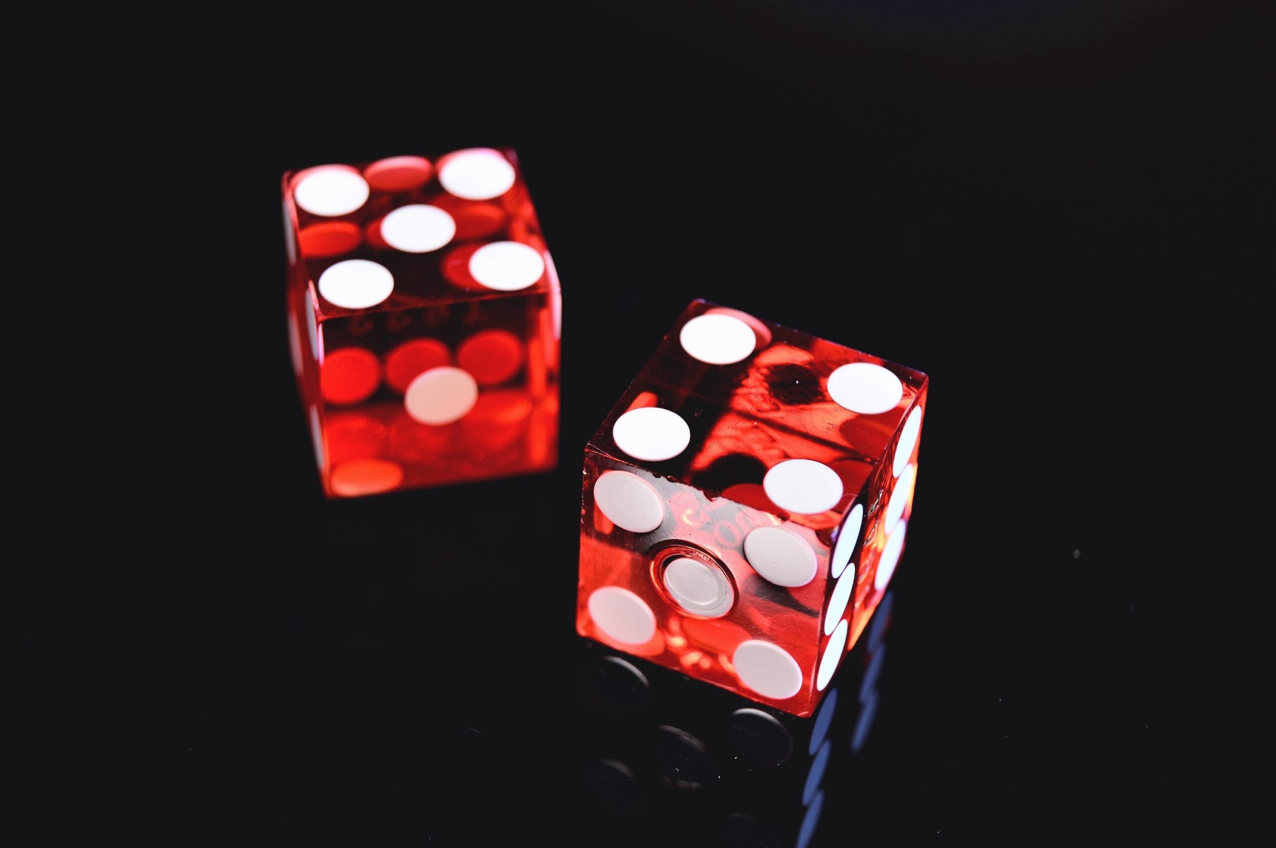 Two red dice showing random numbers on a black background